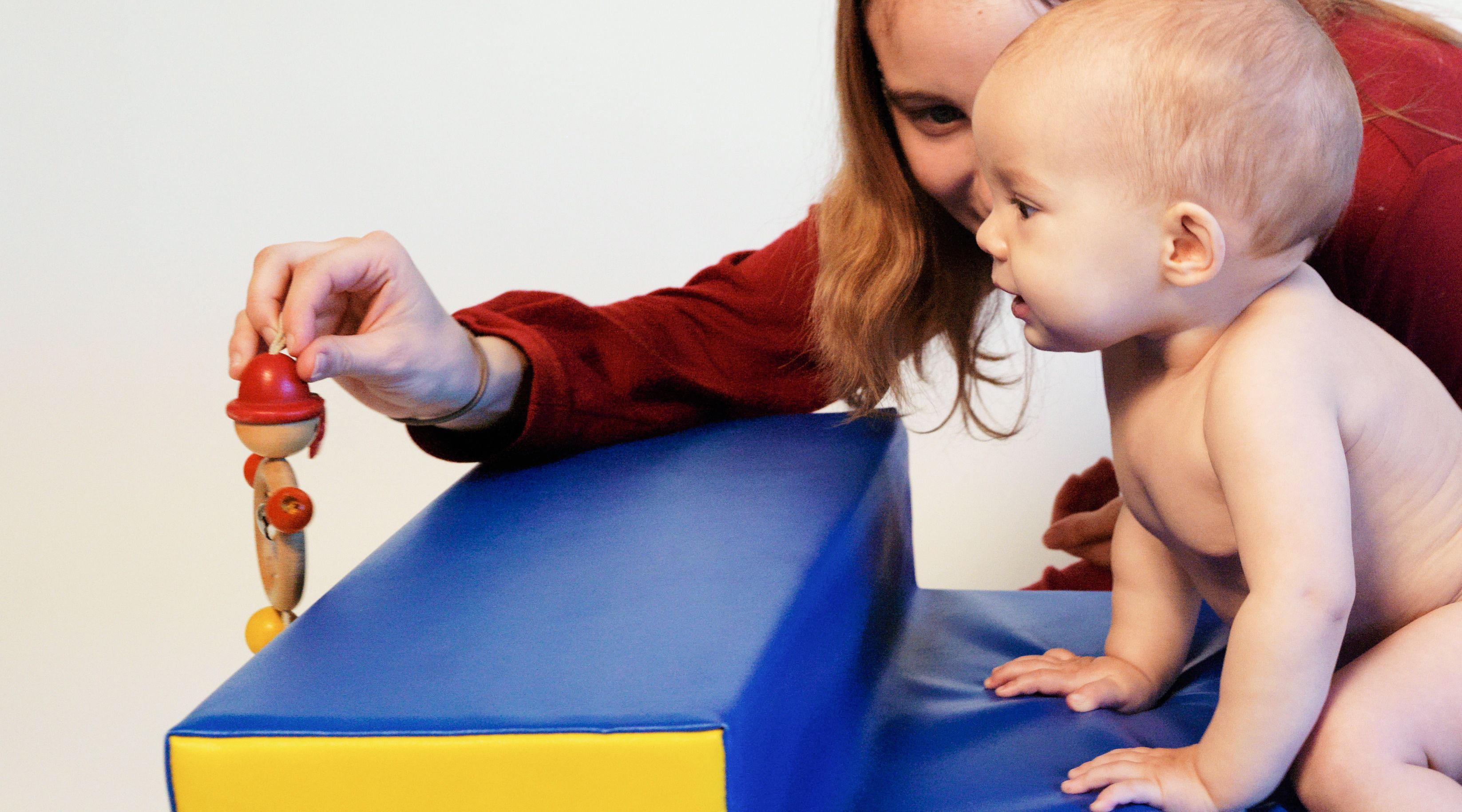 Baby auf Treppe krabbelnd mit Mutter daneben